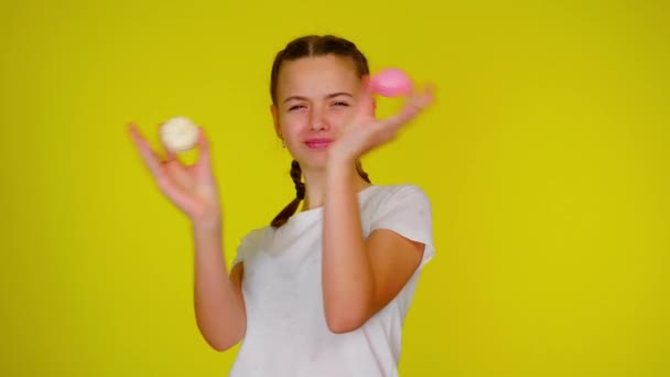 Adolescente chica en una camiseta blanca se juega con macarrones . — Vídeos de Stock