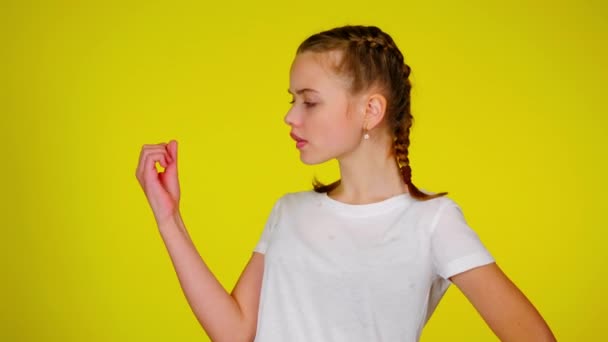 Adolescente menina em uma camiseta branca é olha para sua manicure . — Vídeo de Stock