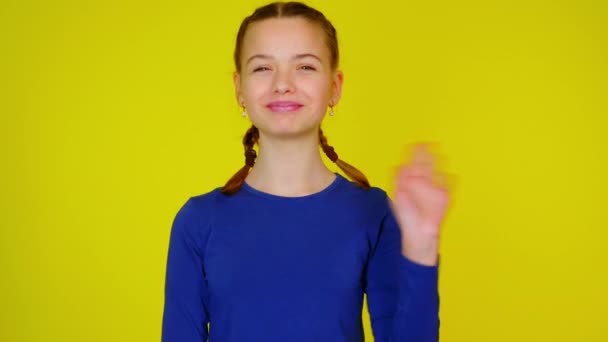 Feliz adolescente en jersey azul ondeando, sonriendo y mirando a la cámara . — Vídeos de Stock