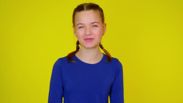 Glad tonåring flicka i blått pullover skrattar och täcker sitt ansikte med handflator. — Stockvideo