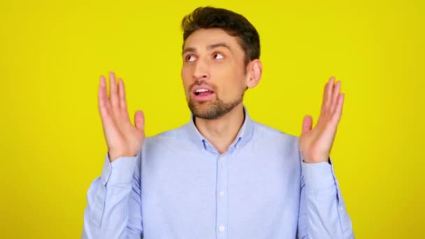 Young man in light blue shirt is shakes hands and rolls his eyes. — Stock Video