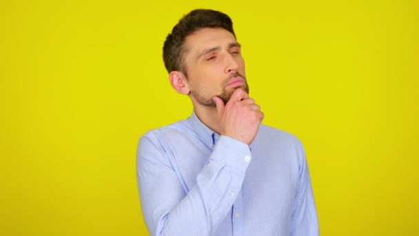 Young man in light blue shirt is looks around at places for text. — Αρχείο Βίντεο