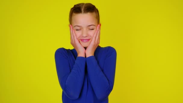 Tonårstjej i blå pullover vidrör ansiktet med handflator och blundar — Stockvideo