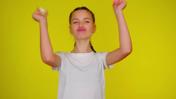 Teenage ragazza in una t-shirt bianca sta ballando con i macaron — Video Stock