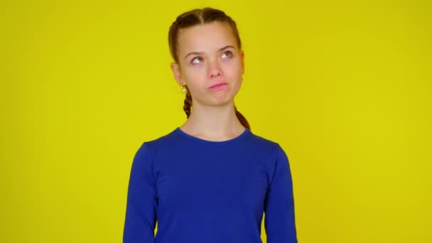 Teenage dívka v modrém svetru se dívá na místo pro text a myslí — Stock video