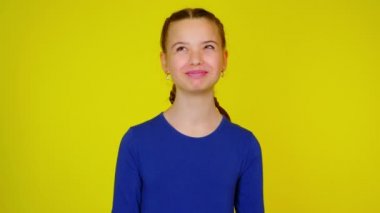 Mavi kazaklı mutlu genç kız flört ediyor, öpüyor ve göz kırpıyor.