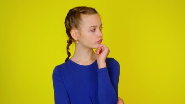 Dospívající dívka v modrém svetru se rozhlíží po místech pro text a přemýšlí — Stock video
