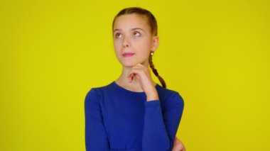 Mavi kazaklı genç kız mesaj atmak için bir yere bakıyor ve düşünüyor.