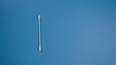 Mavi arka planda kulaklardan kükürt çıkarmak için yeni kulak çubuğu ve metin için yer. Düz-düz