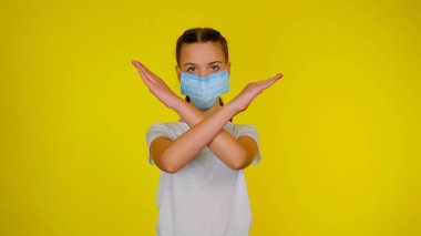 Teen girl in medical holds her arms crossed on yellow background