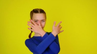 Teenage girl in blue pullover makes a gesture with two hands