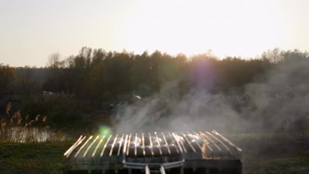 A kolbászt füstben sütik a grillen, naplementekor. — Stock videók