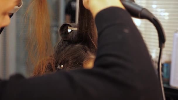 Close up peluquero profesional hace olas rizándose en el pelo de una mujer — Vídeo de stock