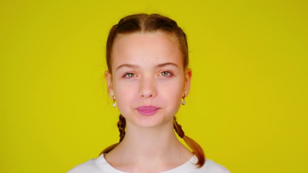 Adolescente chica en una camiseta blanca está posando y mirando a la cámara — Vídeos de Stock