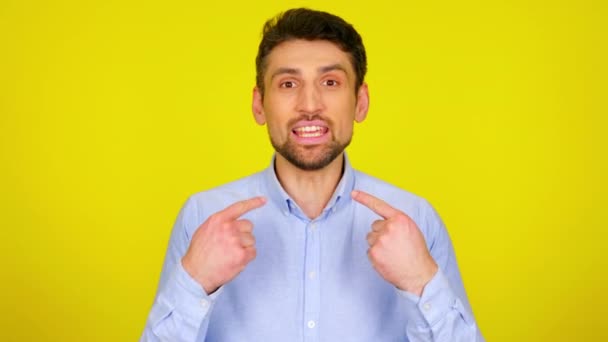 Young man in light blue shirt is points his fingers to himself and says I, me — Stock Video