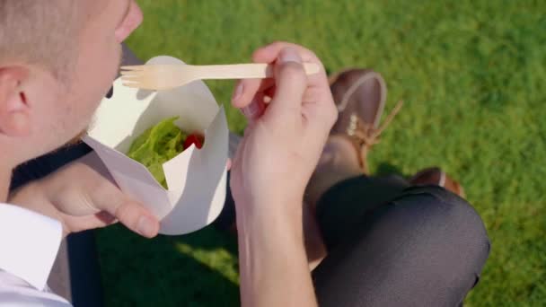 Επιχειρηματίας τρώει λαχανικά με χαρτί οικολογική συσκευασία με ένα ξύλινο πιρούνι — Αρχείο Βίντεο
