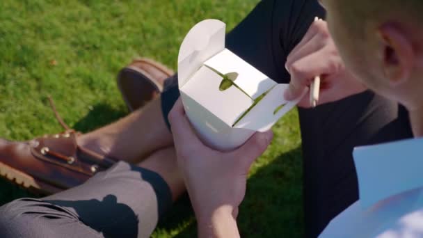 L'homme ouvre un sac écologique en papier avec des légumes et mange avec des baguettes en bois — Video