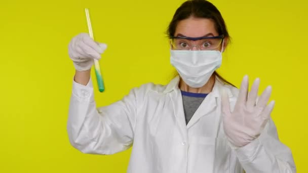 Mulher de vestido médico branco, máscara protetora, com tubo de ensaio, pânico — Vídeo de Stock