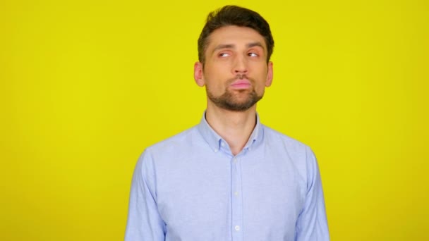 Hombre joven en camisa azul claro es mira a su alrededor en los lugares de texto — Vídeos de Stock