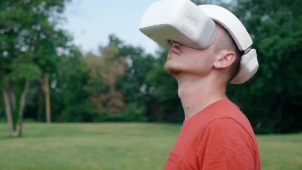 Чоловік у шоломі віртуальної реальності повертає голову вліво і вгору — стокове відео