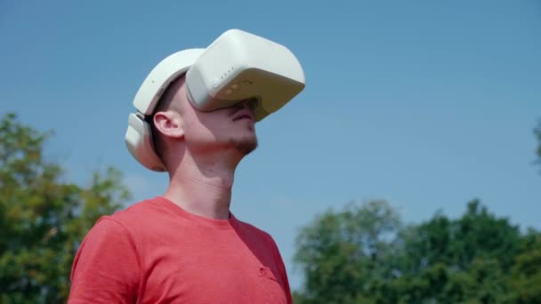 Человек в шлеме виртуальной реальности поднимает голову — стоковое видео