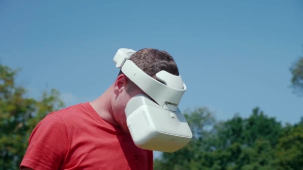 Un homme dans un casque de réalité virtuelle baisse la tête — Video