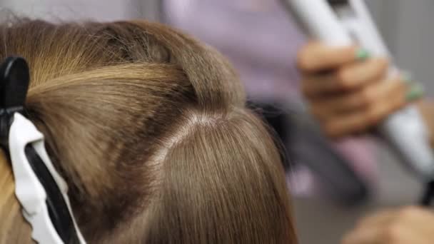 Nahaufnahme professioneller Friseur lässt Wellen auf den Haaren einer Frau rollen — Stockvideo