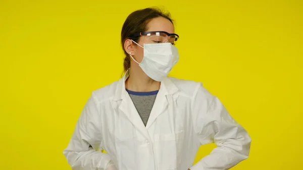 Fiatal orvos védő orvosi maszkban, szemüvegben és fehér köpenyben — Stock Fotó