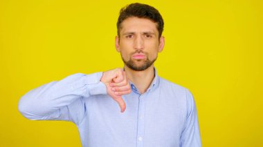 Ciddi bir adam, sarı bir arka planda, kopyalanmış alandan hoşlanmadığını gösteriyor.