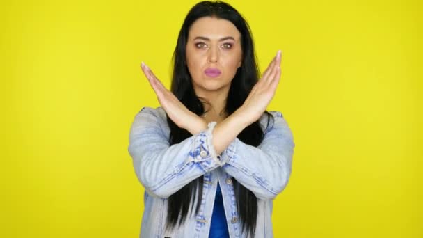 Serious woman crossed arms over her chest on a yellow background with copy space — Stock Video