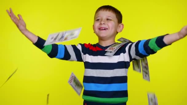 Alegre niño pequeño lanza dinero a sí mismo, sonríe — Vídeos de Stock