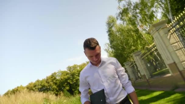 Man met een laptop in de hand, camera beweegt weg van de man en draait 360 graden — Stockvideo