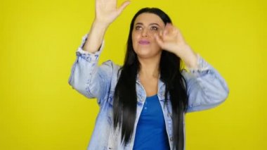 Kadın, sarı arkaplanda hayali cam pantomimcisi ve kopya alanı gösteriyor.