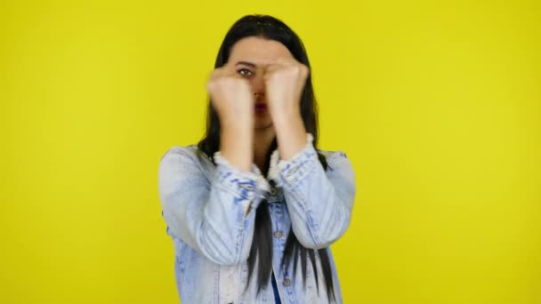 Kvinna gör en gest med två händer och ler på en gul bakgrund — Stockvideo