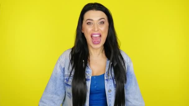 Сумасшедшая женщина кричит и машет головой на желтом фоне с копировальным пространством — стоковое видео