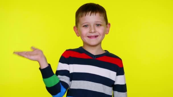 Hej eller hej då. Glada liten pojke ler, vinkar hand och tittar på kameran — Stockvideo
