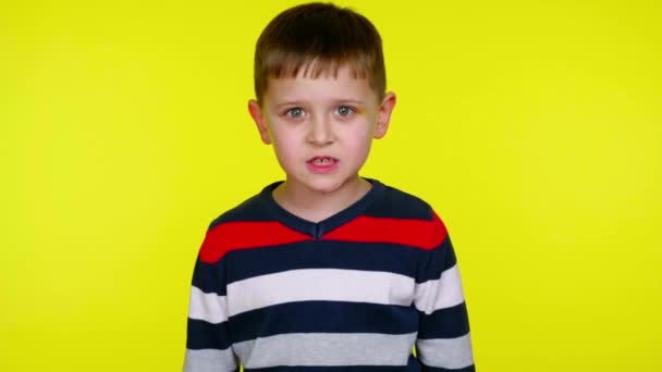 Kafası karışmış küçük çocuk sarı bir arka planda fotokopi aletiyle kameraya hırlıyor. — Stok video