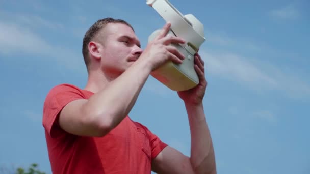 Man in a red T-shirt puts a virtual reality helmet on his head — Stock Video