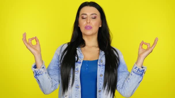 Žena s medituje, vdechuje vzduch a směje se na žlutém pozadí — Stock video