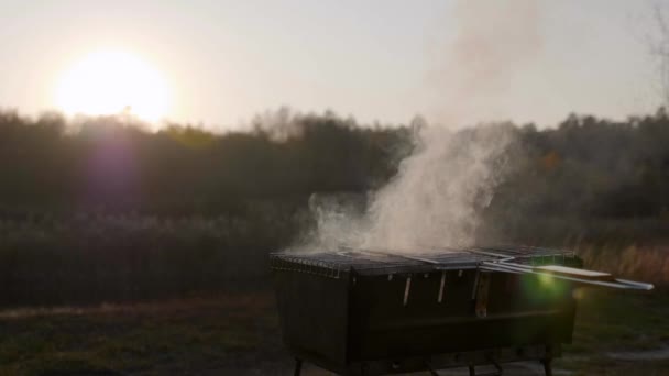 Klobásy se vaří v kouři na grilu na pozadí západu slunce — Stock video