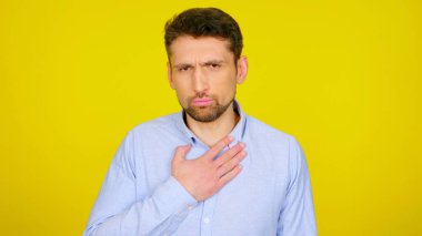 Eli göğsünde hasta bir adam, sarı bir arka planda, kopyalama alanı var.