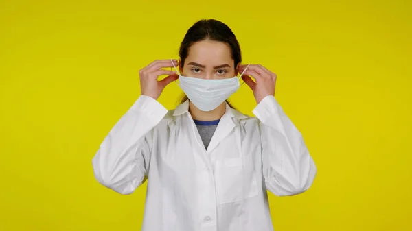 Fertőző betegség orvos tesz egy védő orvosi maszkot az arcára — Stock Fotó