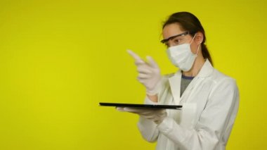 Maskeli kadın tablet ekranda geleceğin holografik teknolojisini kullanıyor.
