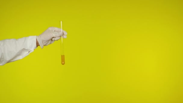 Ruka v latexové rukavici ochrana ukazuje skleněnou trubici s látkou — Stock video