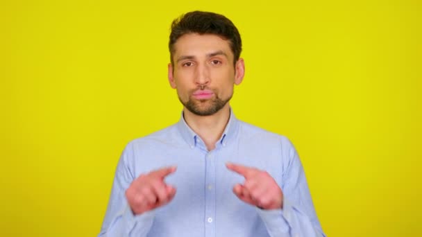 Sweet young man in light blue shirt draws a heart in the air with his fingers — Stock videók