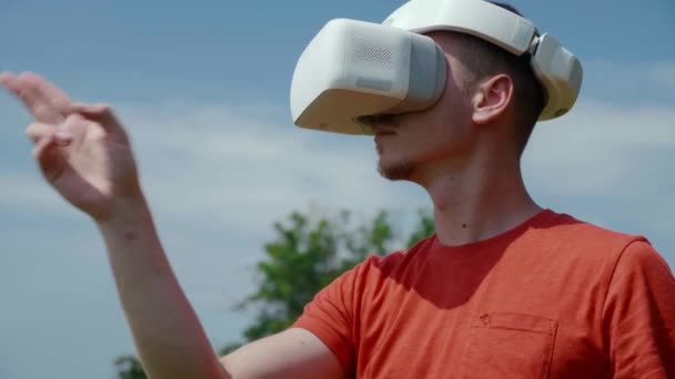 Der Mann im Virtual-Reality-Helm steuert Gesten. 4K-Filmmaterial — Stockvideo