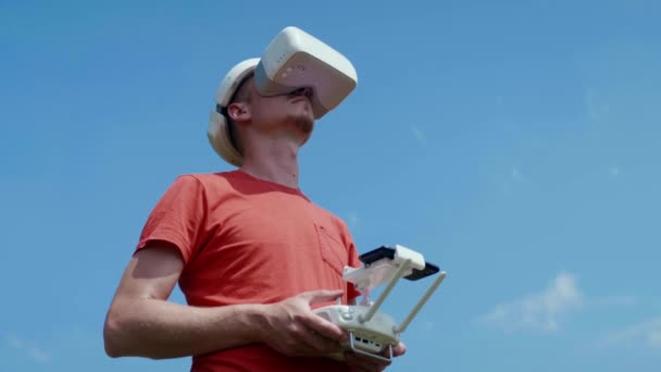 Человек управляет квадрокоптером через пульт дистанционного управления — стоковое видео