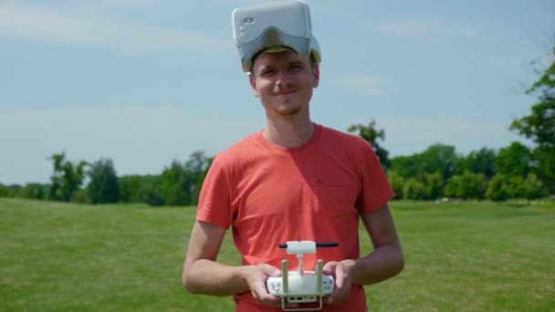 Man in glasses, for a quadrocopter and with a remote control in hands and smiles — Stock Video
