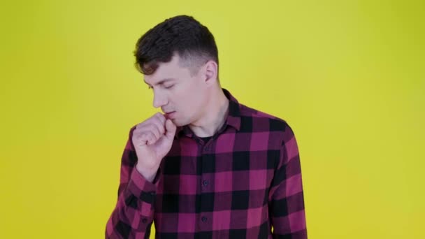 Homem doente tosse fechando a boca com o punho em um fundo amarelo — Vídeo de Stock