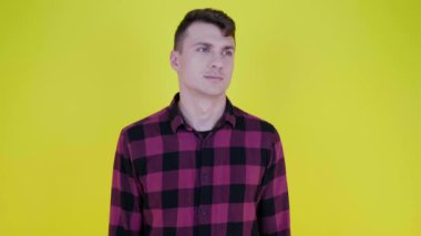 Düşünceli adam etrafına bakar ve sarı arka planda ne seçeceğini düşünür.